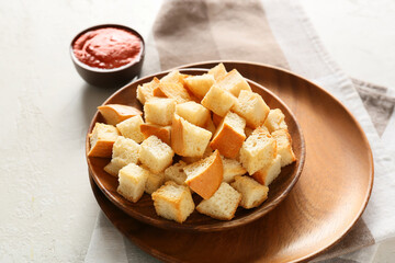 Bowls with tasty croutons, sauce and napkin on white background