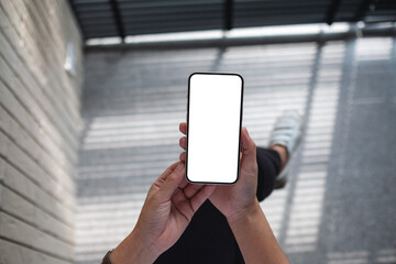 Top view mockup image of a woman holding mobile phone with blank white screen