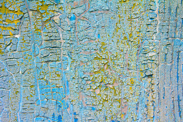 Cracked blue and yellow paints on old wooden wall. Abstract grunge vintage rustic texture. 