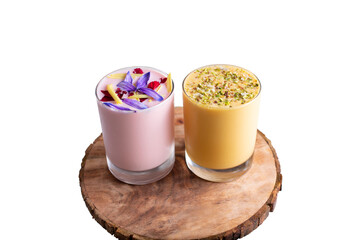 A view of a lavender lassi and mango lassi beverages, on a wood board.