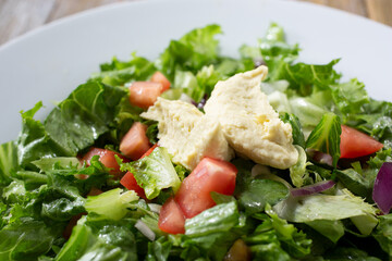 A closeup view of an Ethiopian salad with romanat dressing.