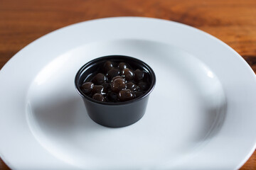 A view of a condiment cup filled with honey boba.
