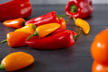 A closeup view of a pile of red, orange, and yellow sweet peppers.