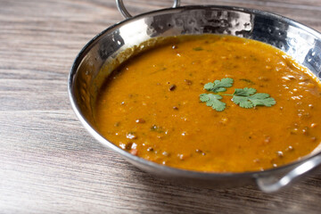 A view of butter chicken, in a karahi bowl.