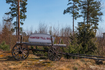 Vanersborg, Sweden A land for sale sign on an old wagon in a meadow, Tomter till salu in Swedish...
