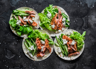 Grilled salmon, iceberg lettuce, cucumber and homemade mayonnaise tortilla sauce on a dark...