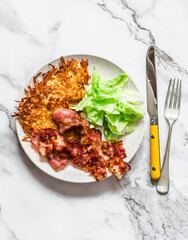 Delicious breakfast, brunch, tapas, snack - latkes potatoes, fried bacon and green salad on a light background, top view
