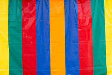 A view of a multi-colored thick stripe tent tarp, as a background.