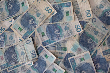 Fototapeta na wymiar Many randomly scattered paper bills with the face value of fifty Polish zloty.