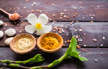 Organic pure Powder Turmeric and Tanaka clay cup with fresh frangipani flowers perfumery,himalaya salt on wooden background. ancient herb herbal of thailand. Aromatherapy Spa set.massage oriental.