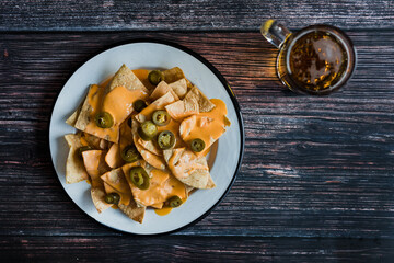 Mexican nachos chips with american cheese, beer and jalapeños in Mexico Latin America