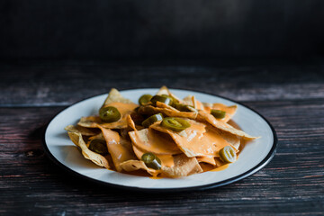 Mexican nachos chips with american cheese, beer and jalapeños in Mexico Latin America