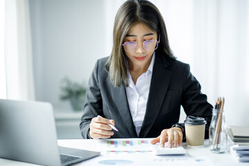 Portrait of young Asian businesswoman using write notebook laptop in home office. Beautiful girl at desk computer take home order. Startup business asia woman online sme telemarketing.
