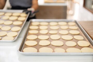 Selective focus and blurred background of beautiful bright and white decorative bakery kitchen with people or chef is working to prepare dough for making fresh dessert and bread for lunch or dinner.