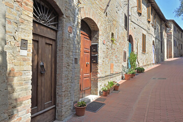 Fototapeta na wymiar facade of stone houses in a paved street in Italy - tuscany - marcialla village