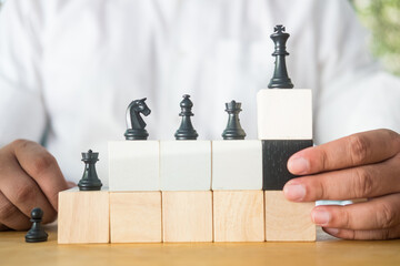 Chess standing on a pyramid of wooden building blocks. Career ladder concept