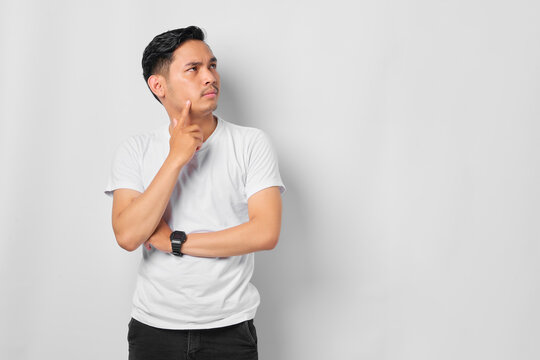 Pensive young Asian man with a serious face thinking about a question, thoughtful about confusing idea isolated on white background