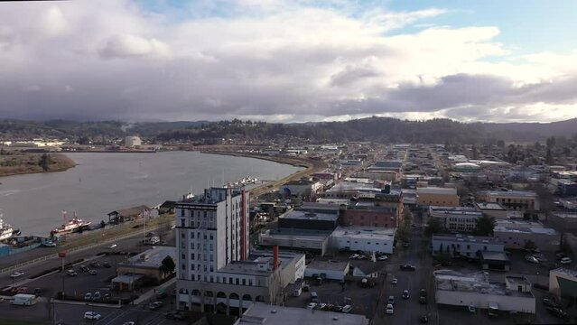 Coos Bay Oregon, USA. 4k drone orbit around tall building with view of harbor.