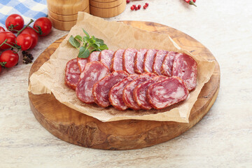 Sliced salami sausages over board