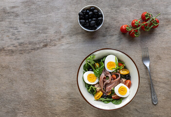 French composed salad with tuna, anchovy, hard-boiled eggs, tomatoes, and black olives.