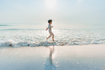 Fototapeta premium The boy ran to the sea in the morning while still wearing pajamas.