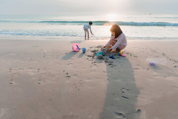 Children playing in the sand by the sea in the morning although still wearing pajamas