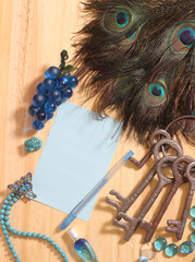 Notepaper and Pen on Table Surrounded By Peacock Feathers and Jewelry