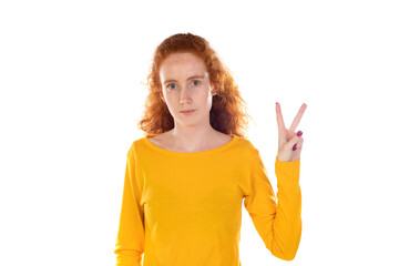 Redheaded pretty woman smiling gesturing victory or peace