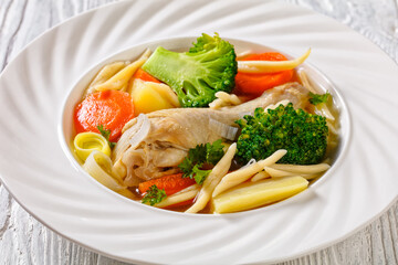chicken vegetable soup with pasta in white bowl