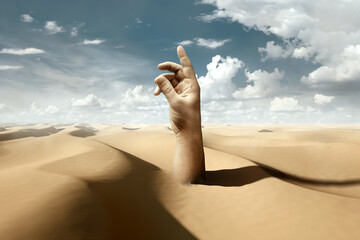 A human hand sticks out of the sands in the desert against a blue sky. Metaphor shifting sands, problems, depression, fatigue, procrastination. mixed media. - obrazy, fototapety, plakaty