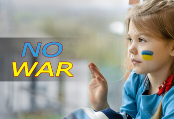 Portrait of an 8-year-old girl with a Ukrainian flag on her face, sitting by the window. Lettering No war
