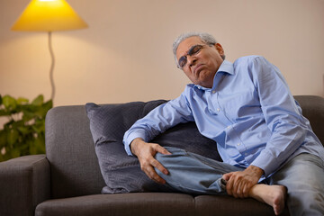 Portrait of a senior man suffering from knee pain 