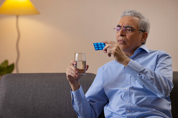 Portrait of senior man reading name of medicine in hand 