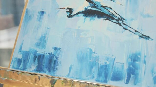 Art uses sponge finishing touches on acrylic painting of herns