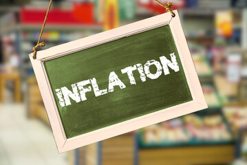 Ein Supermarkt und Tafel mit dem Hinweis auf steigende Inflation