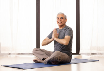 Portrait of an active senior man meditating at home