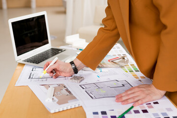 Woman architect working on interior renovation in workplace. Designer choosing color samples...