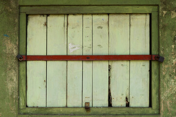Shop window locked and closed by red iron bar