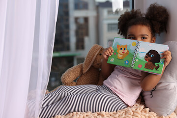 African American girl with book at home