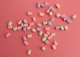Multicolored candies on a pink background. Close-up