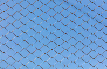 Fototapeta premium Metal mesh against the blue sky.