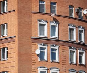 Obraz premium Windows and walls of a multi-storey brick house.