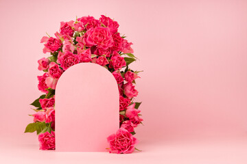 Spring fresh pink roses as decorative framing of arch for presentation cosmetic products or goods,...