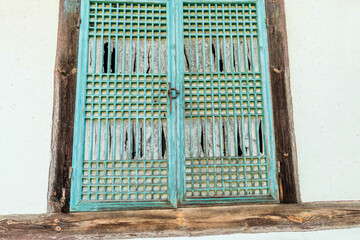 Exterior of old wooden lattice window on oriental building in public park.