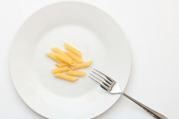 白い皿に少量のパスタと添えられたフォーク