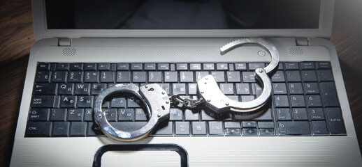 Handcuffs on the computer keyboard. Cyber crime