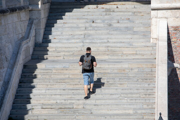people walking by stone stairs with backpack