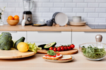 Image of sandwiches with vegetables on plate with other fresh vegetables on wooden board preparing...