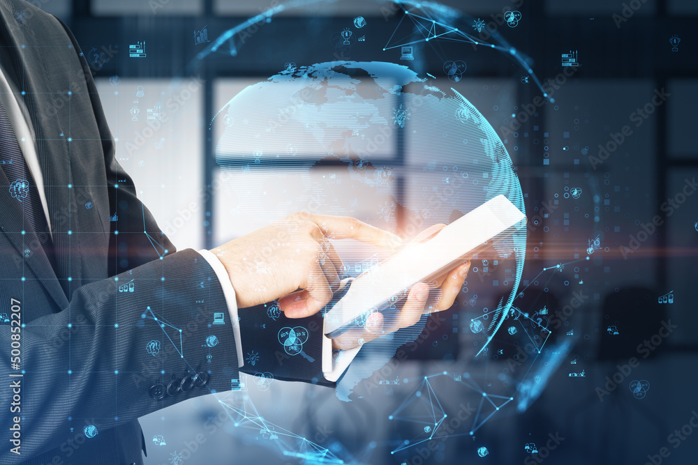 Poster close up of businessman hand pointing at tablet with glowing polygonal globe with social icons on bl