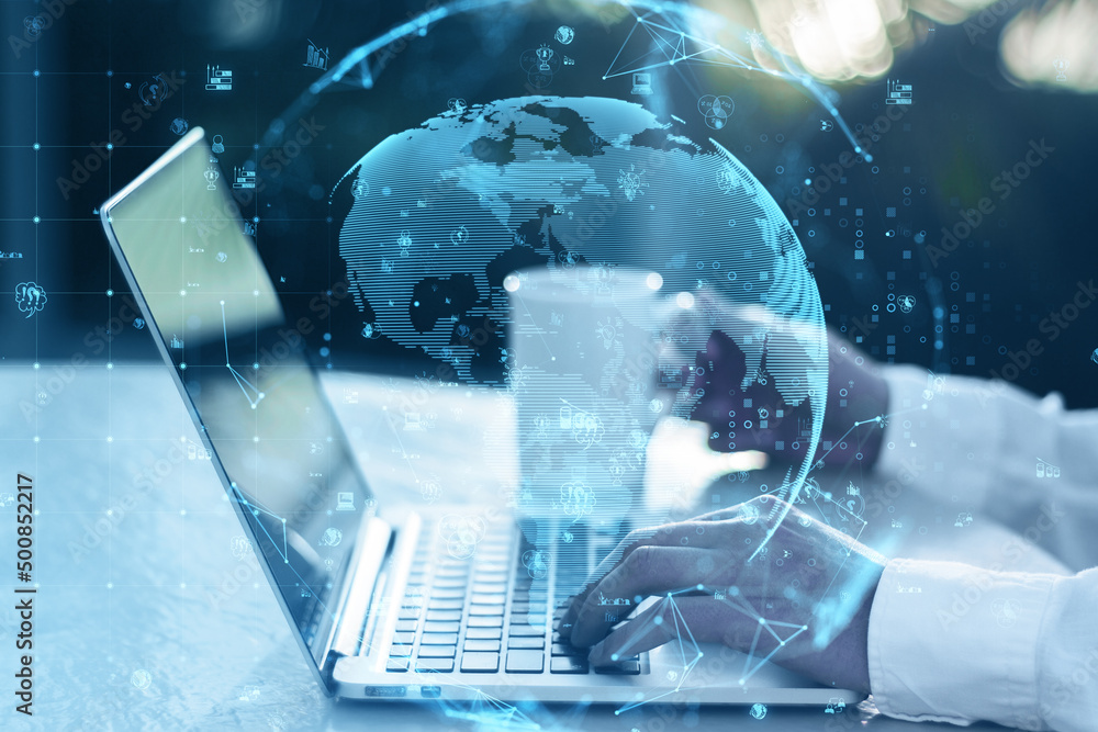 Poster close up of hands using laptop on desktop with coffee cup, glowing polygonal globe and social icons 